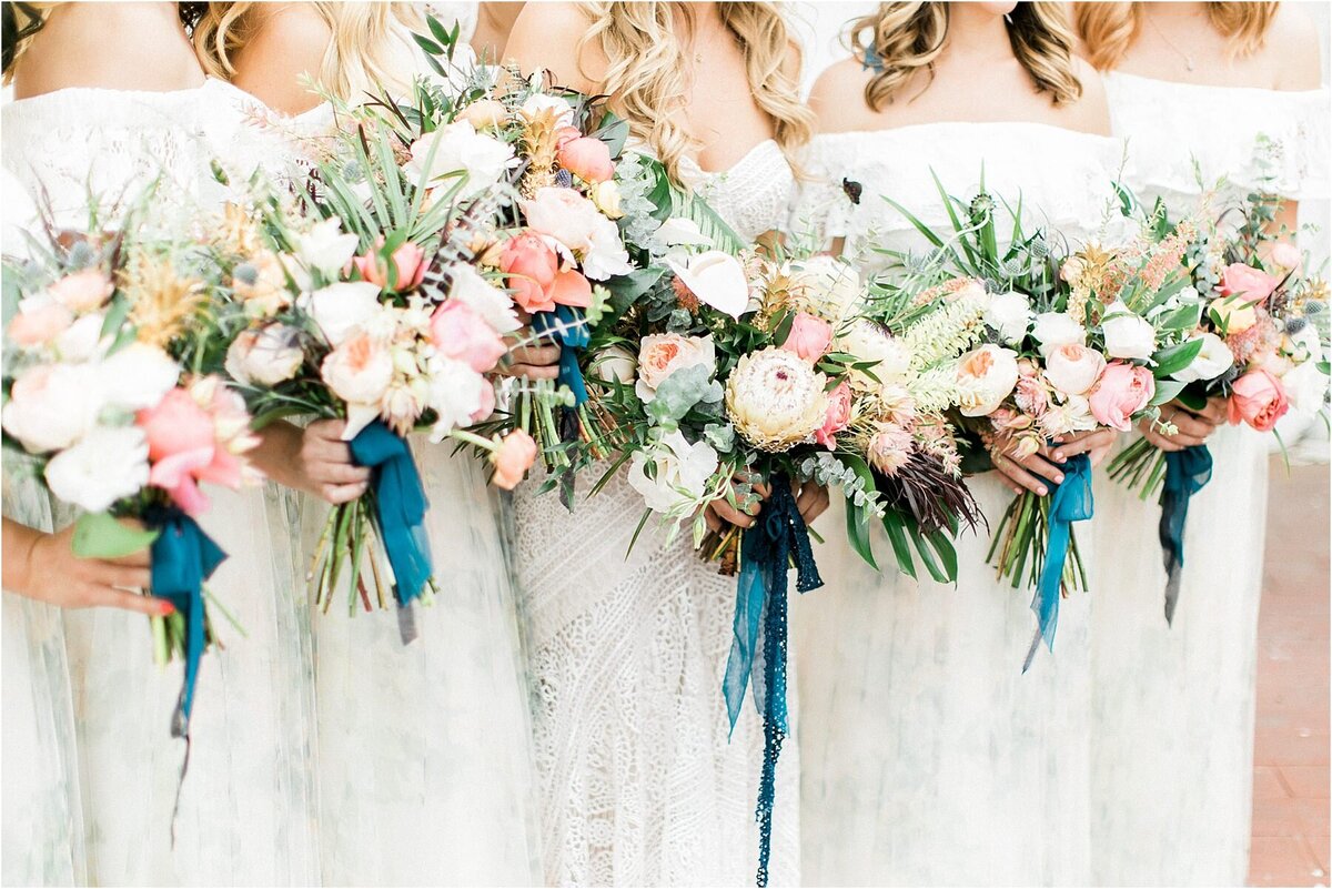 Garden rose and ranunculus bouquets with trailing silk ribbon