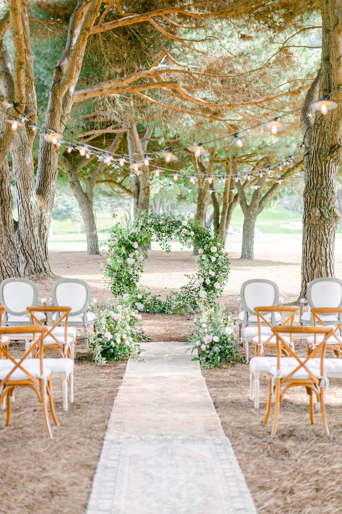 Ceremony aisle and floral arch in a garden courtyard