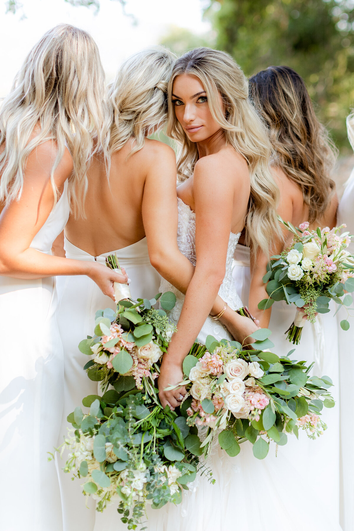 Bridesmaids gathered with blush bouquets