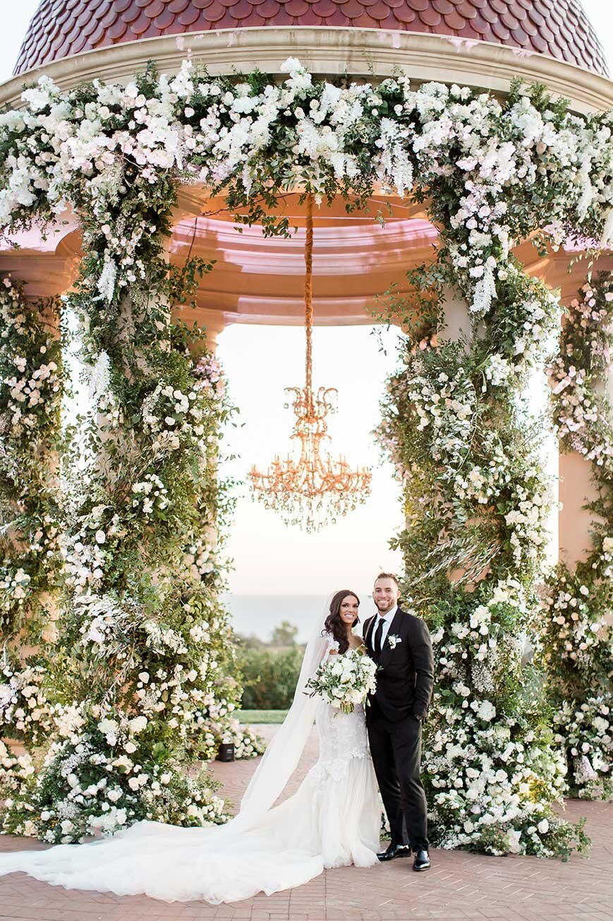 Bride and groom at the flower-wrapped rotunda at Pelican Hill