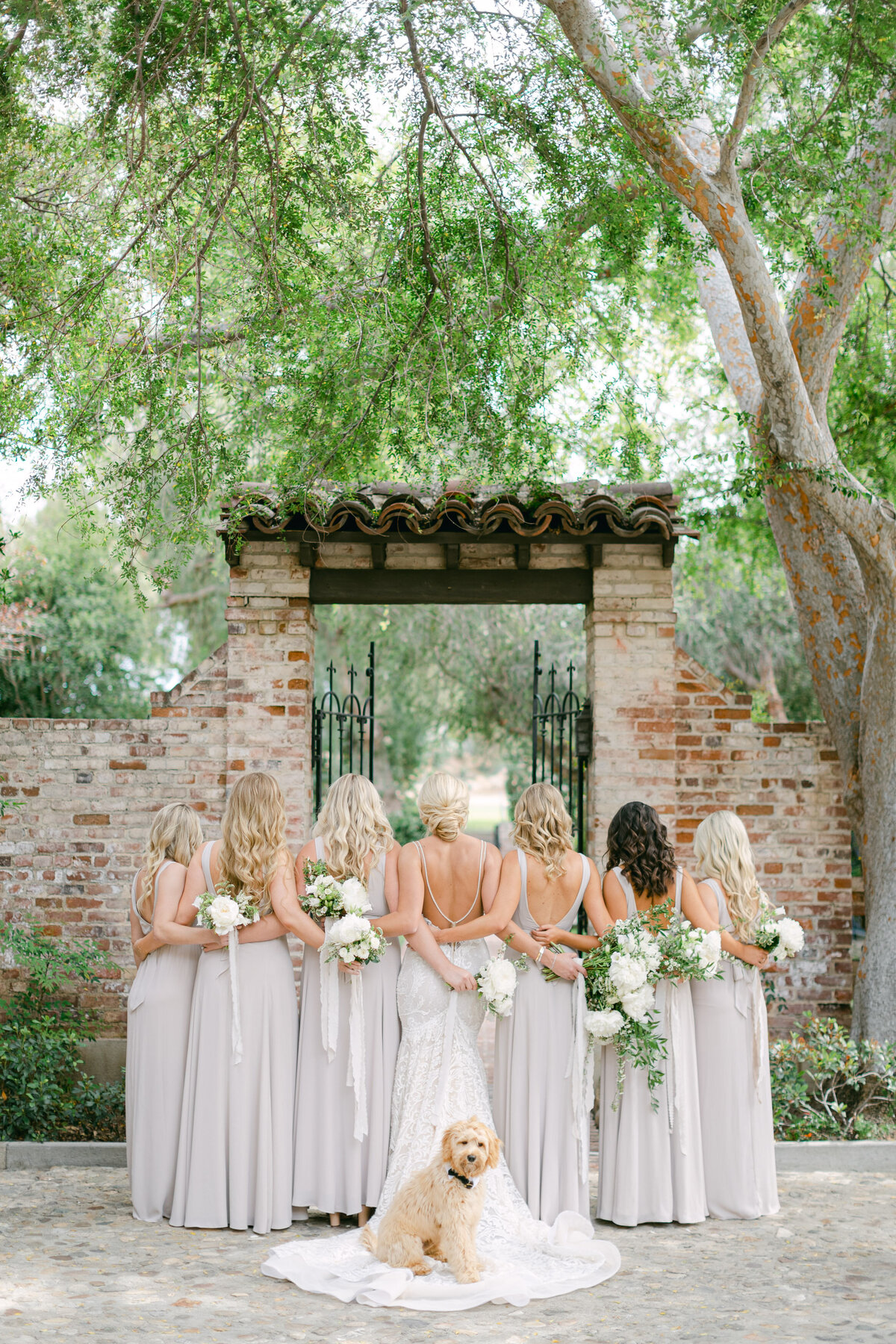 Bridesmaids in soft neutrals on a garden path