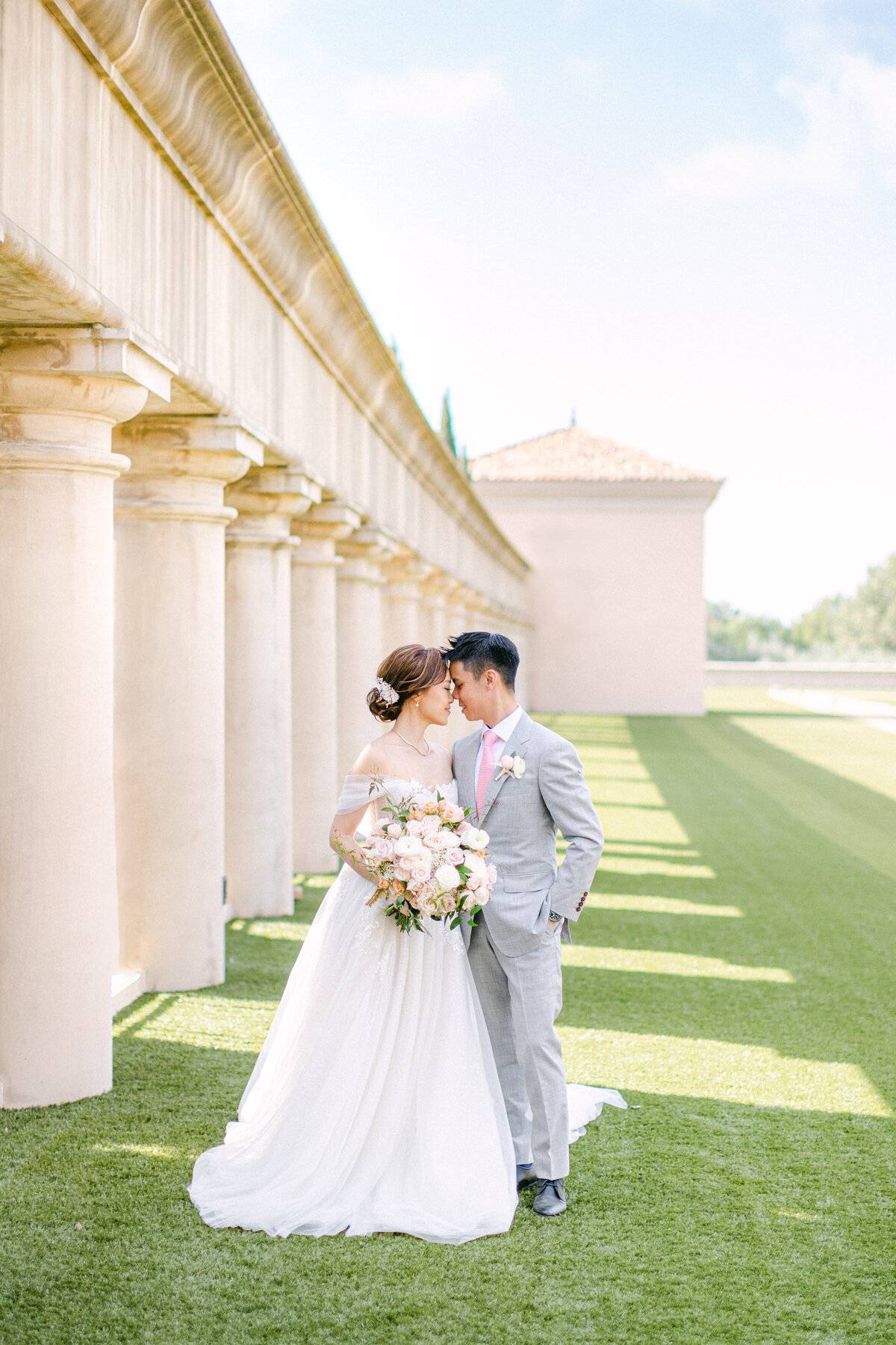 Bride and groom crossing the colonnade lawn