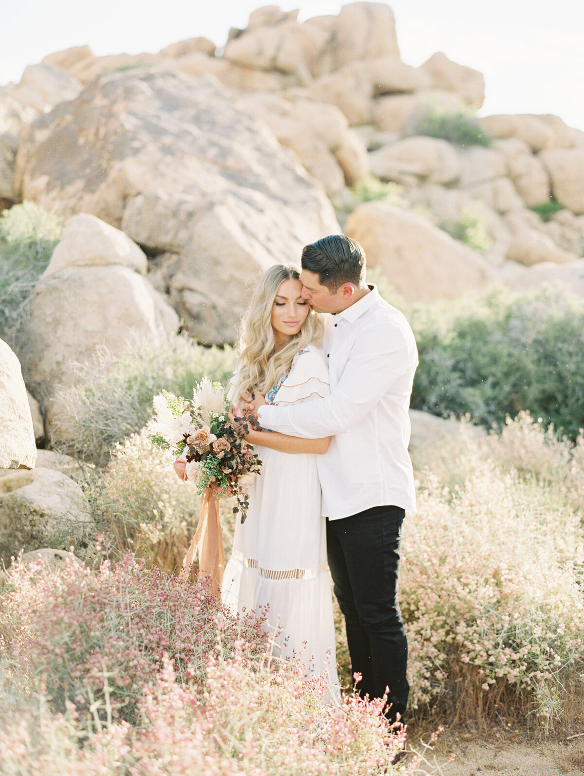Bride and groom among desert boulders