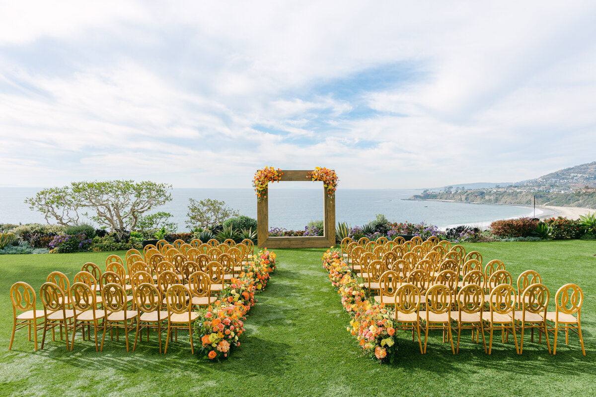 Ceremony arch of autumn blooms overlooking the water