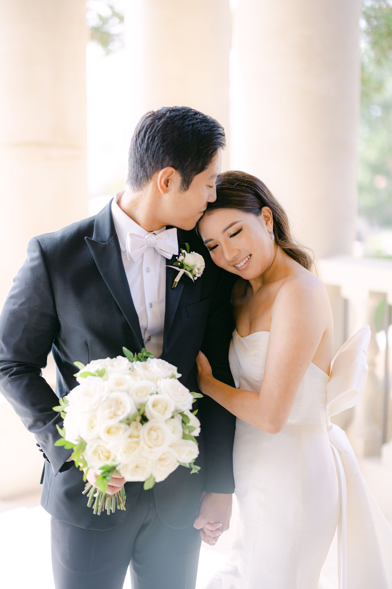 Heads together, white roses in hand