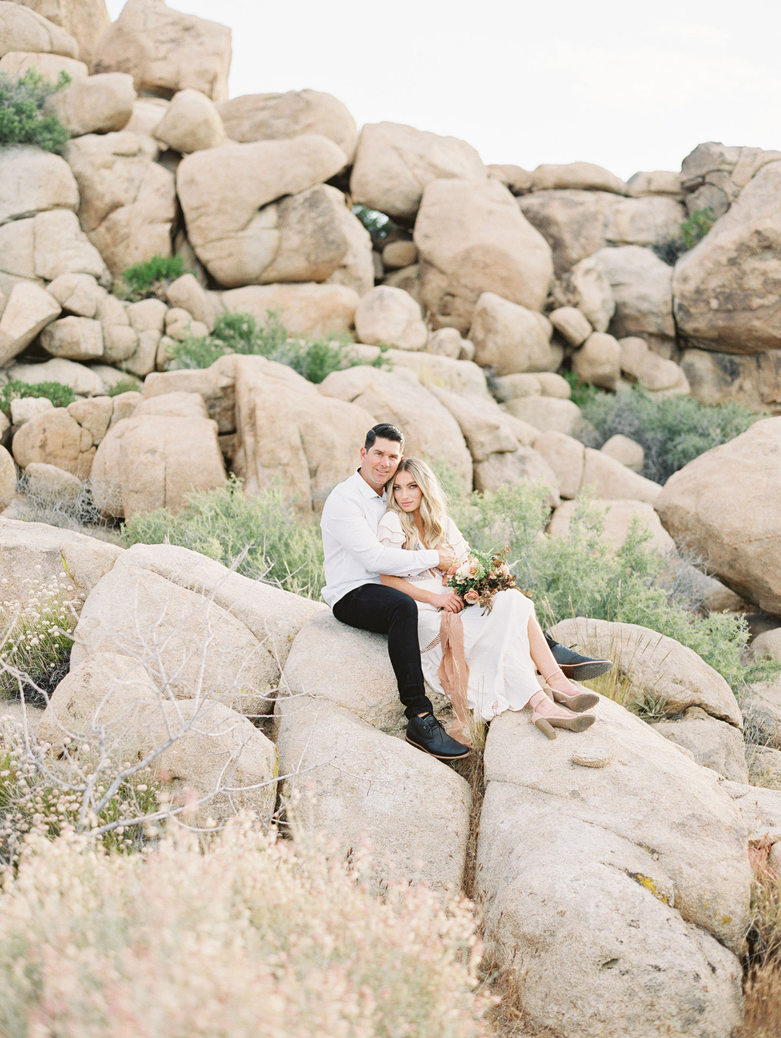 An engaged couple on the boulders in Joshua Tree
