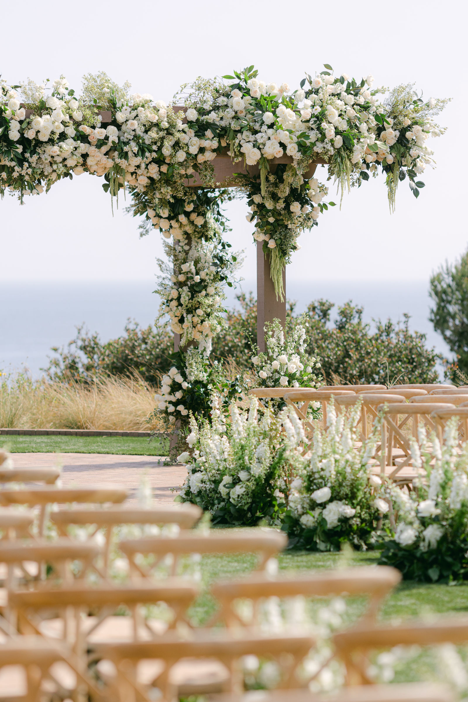 Greenery and white florals over the ceremony arch at Terranea