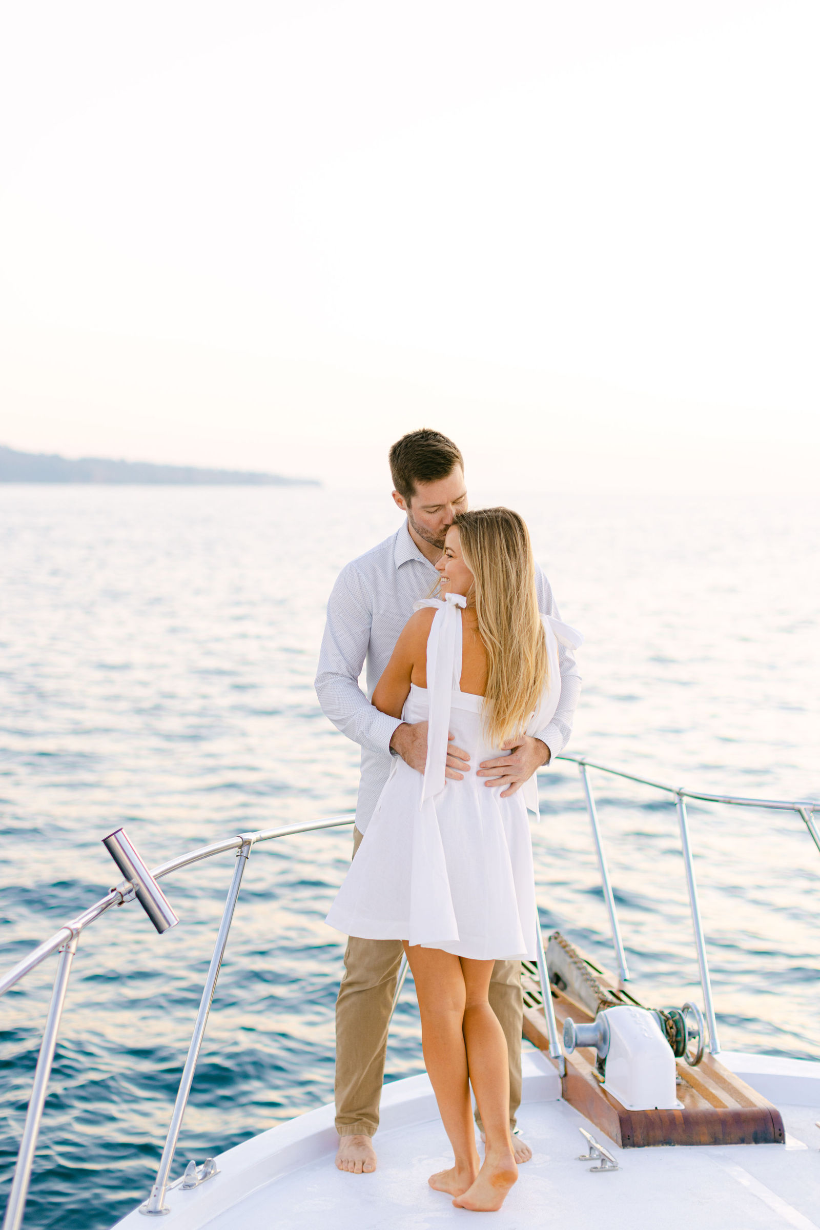 An embrace on the bow, backlit at golden hour