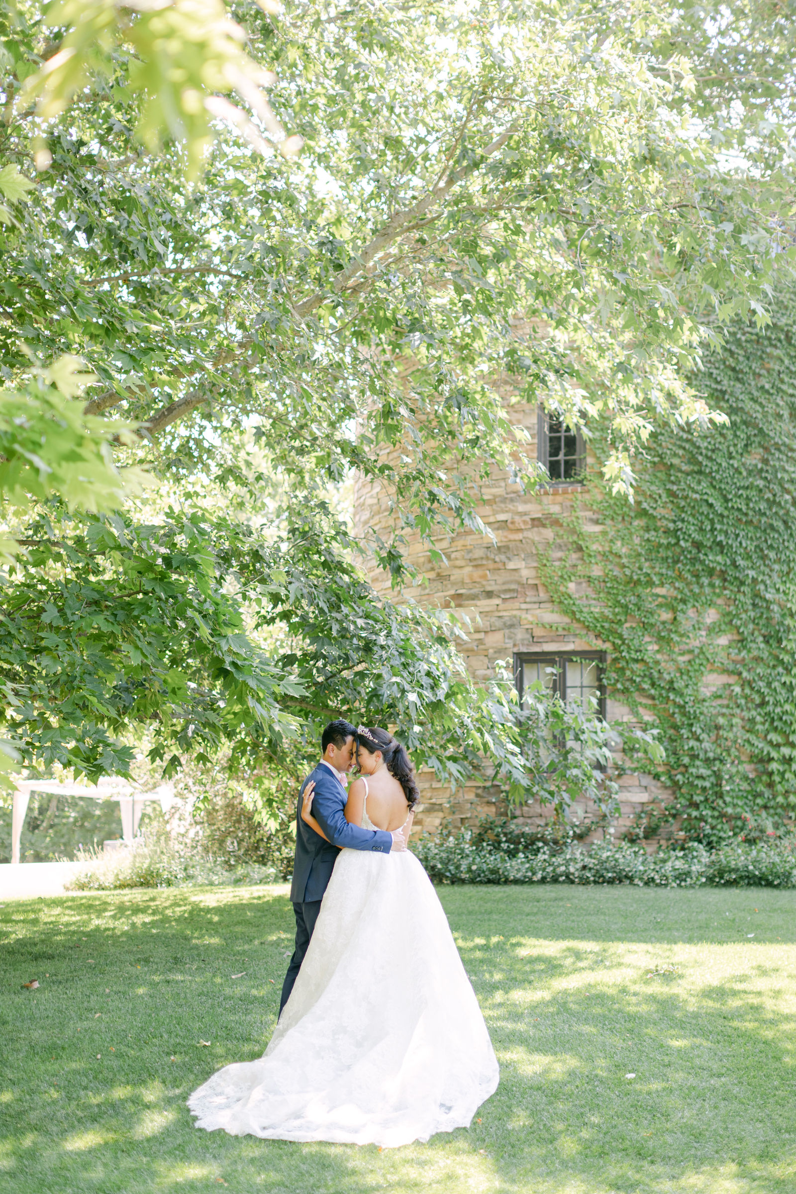 An embrace beneath the sycamore, the ivy-covered stone tower behind