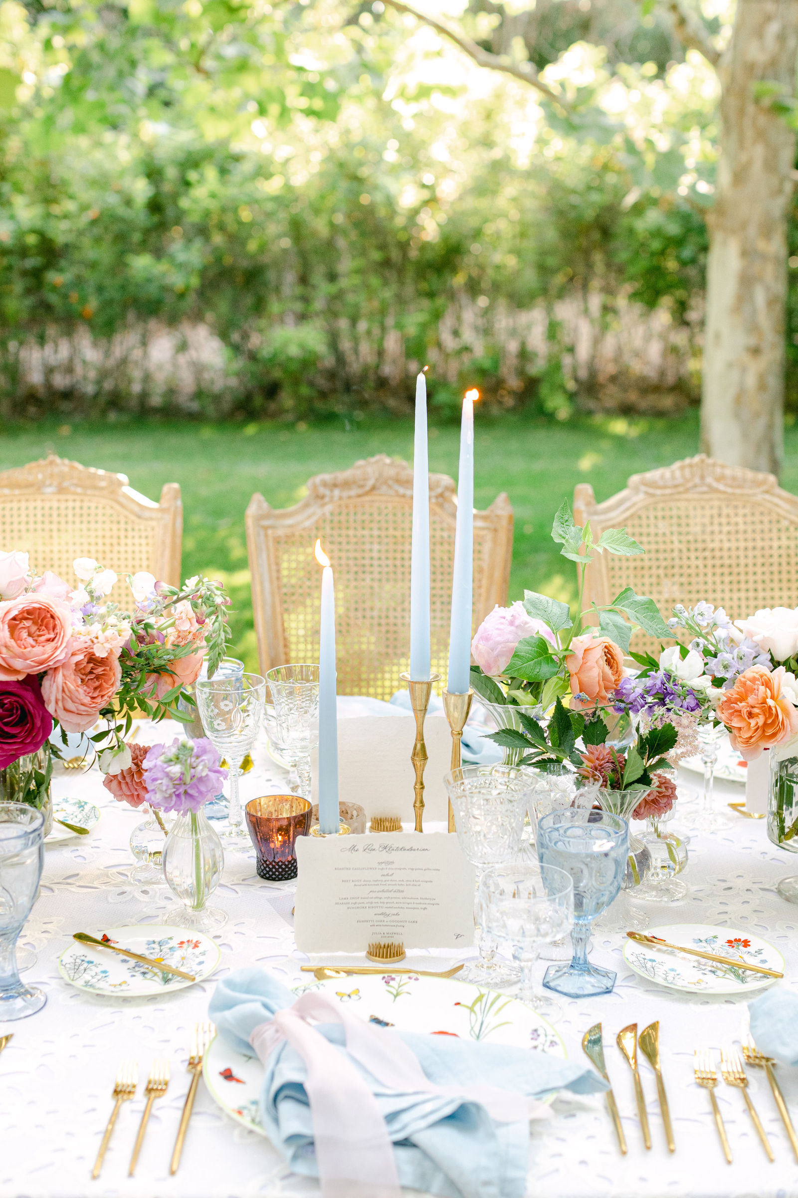 Blue taper candles and garden roses down the reception table at Kestrel Park