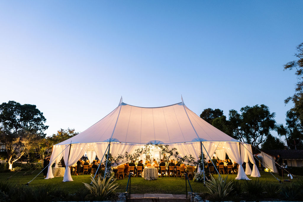 The sailcloth tent glowing at dusk on the Croquet Lawn