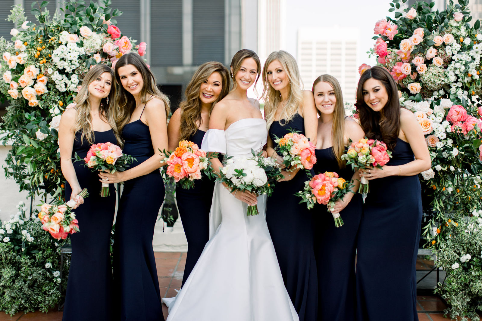 Bridesmaids in navy with coral peonies on the rooftop at the Jonathan Club